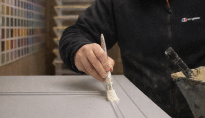 paul barber jnr painting a kitchen door in the workshop