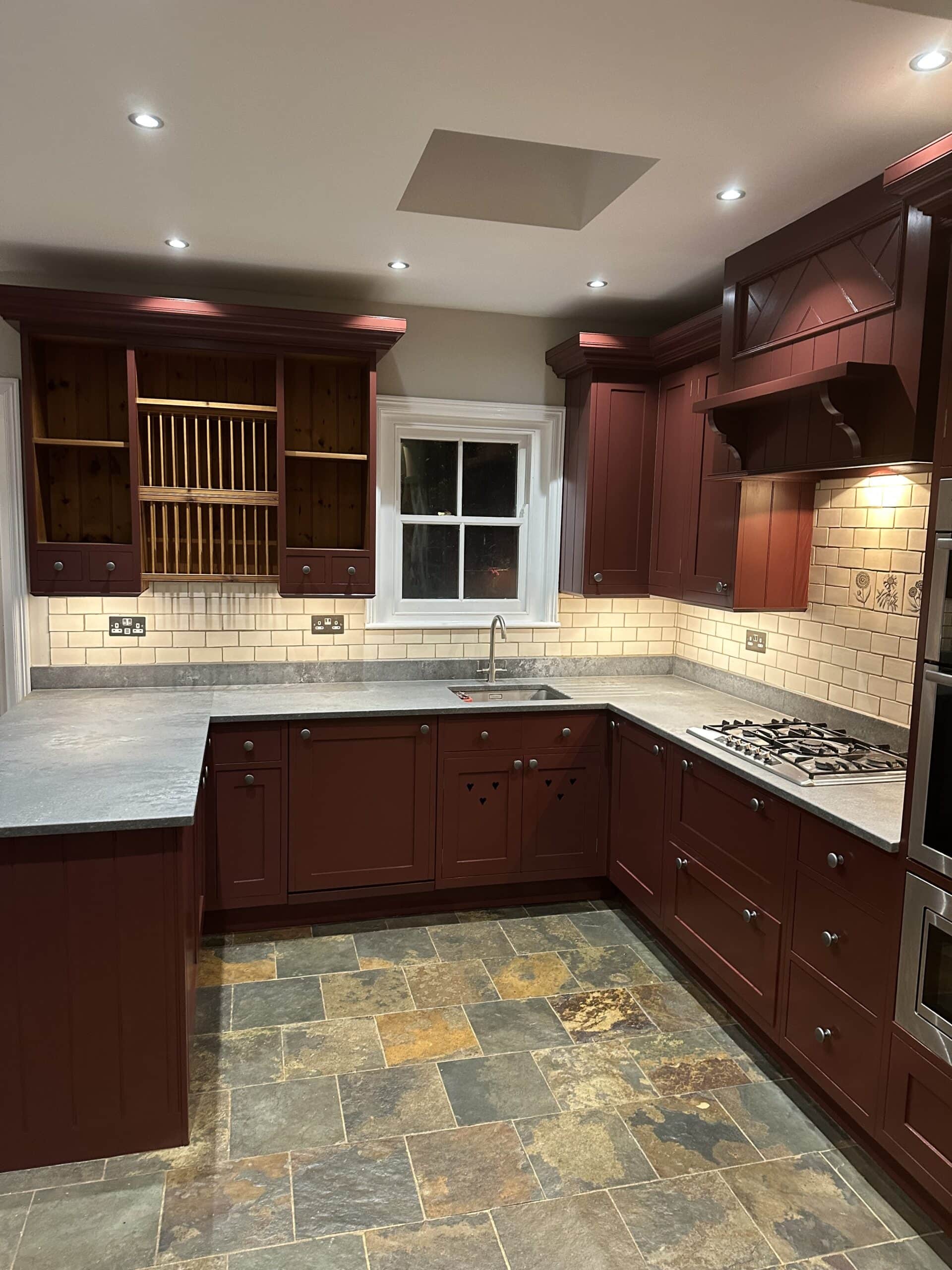 Deep red hand painted kitchen finish on reclaimed pine cabinetry